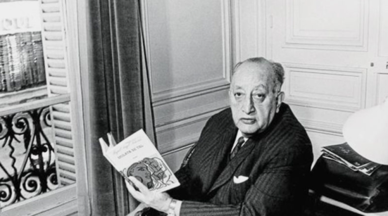 Miguel Ángel Asturias sentado junto a una ventana, sosteniendo un libro abierto.