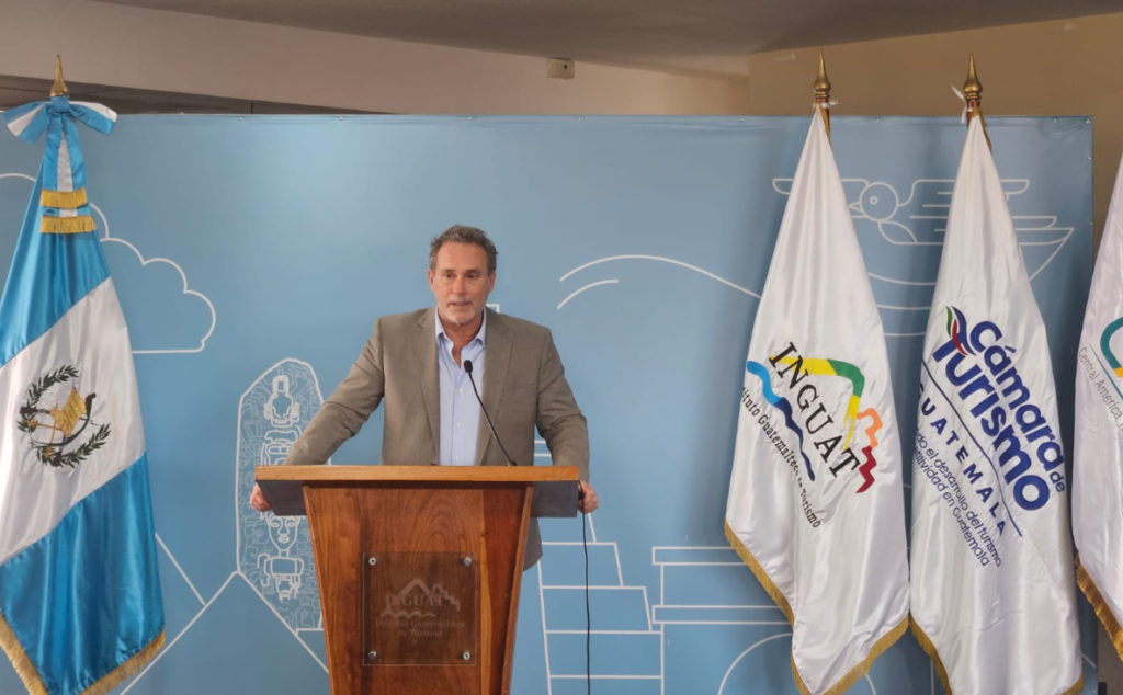 Presentación de CATM 2026: un expositor en el podio, junto a las banderas de Guatemala, Inguat y la Cámara de Turismo.