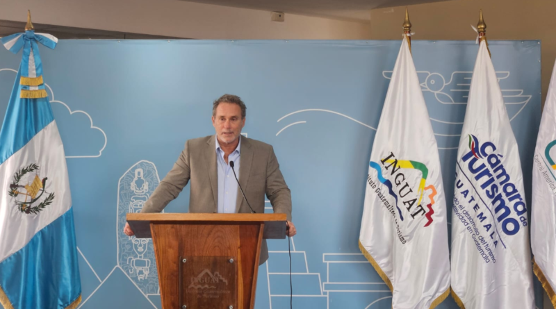 Presentación de CATM 2026: un expositor en el podio, junto a las banderas de Guatemala, Inguat y la Cámara de Turismo.
